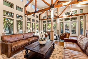 A living room with a brown leather couch and a wooden coffee table. at Bridge at Heritage Woods, Texas